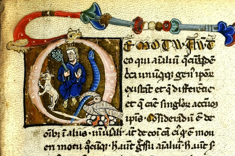 Illuminated manuscript detail with a robed figure inside a gold initial beside lines of Latin text.