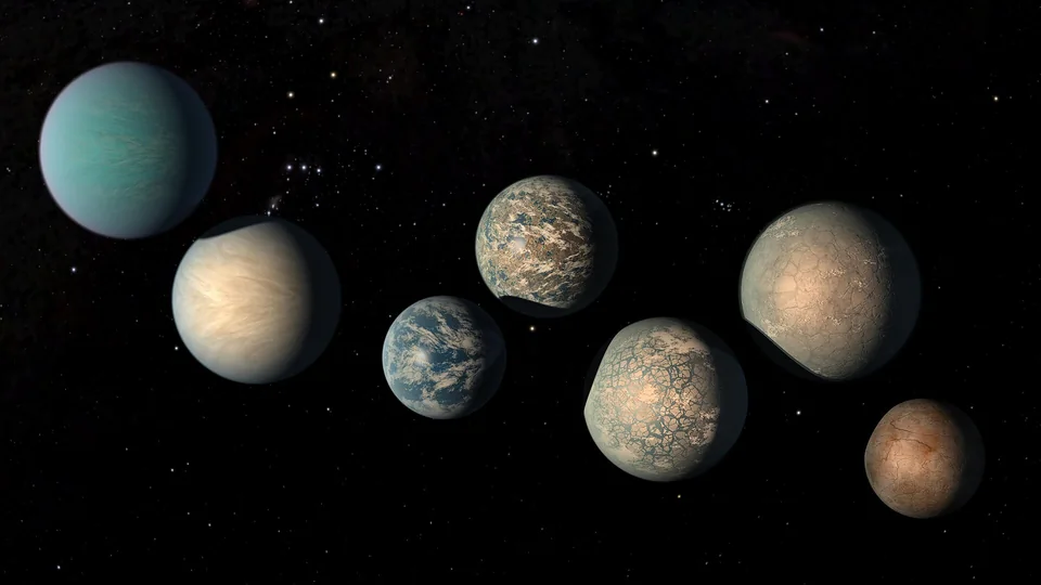 Seven imagined rocky planets of different colors arranged against a black star field.