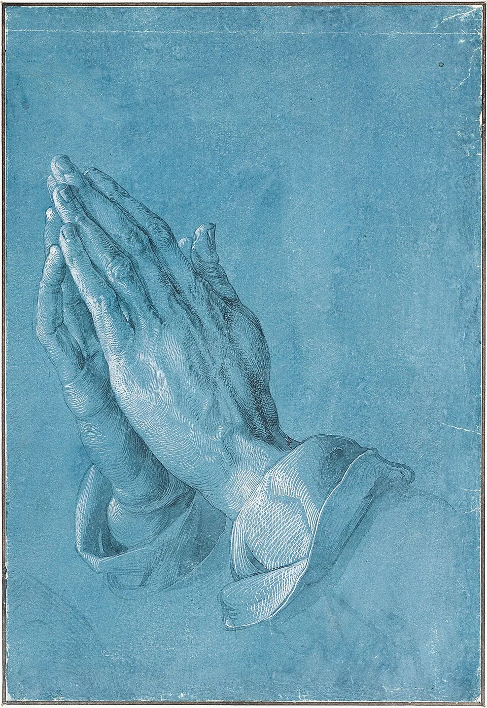 Dürer’s detailed drawing of two hands pressed together in prayer, rendered in gray and white on blue paper.