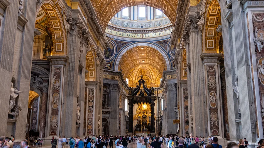 Gilded vaults and monumental stone columns inside St. Peter’s Basilica.