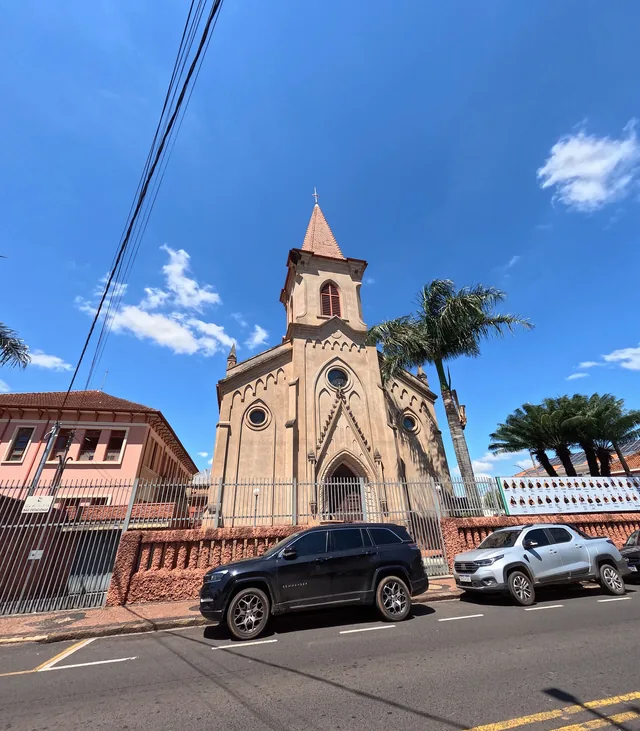 The Gothic revival Chapel of Saint Paula Frassinetti in Brazil, framed by palm trees.