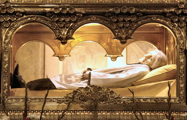 John Vianney’s vested reliquary display at Ars-sur-Formans, photographed in 2005. The visible face, hands and clothing are not a measurement of untreated tissue.