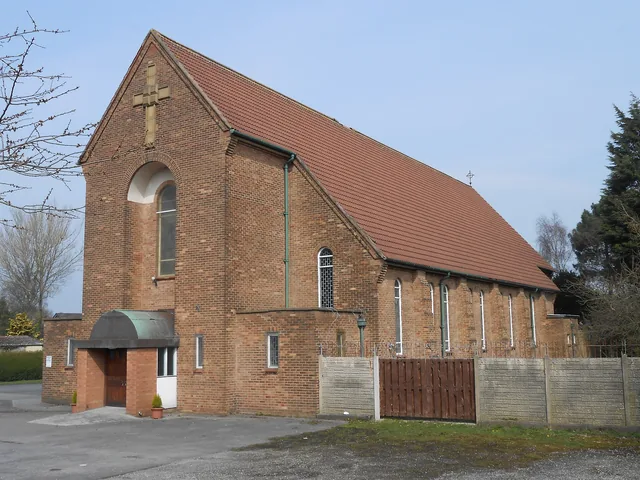 St Maria Goretti Church in Preston, a red brick parish church with a cross above the entrance.
