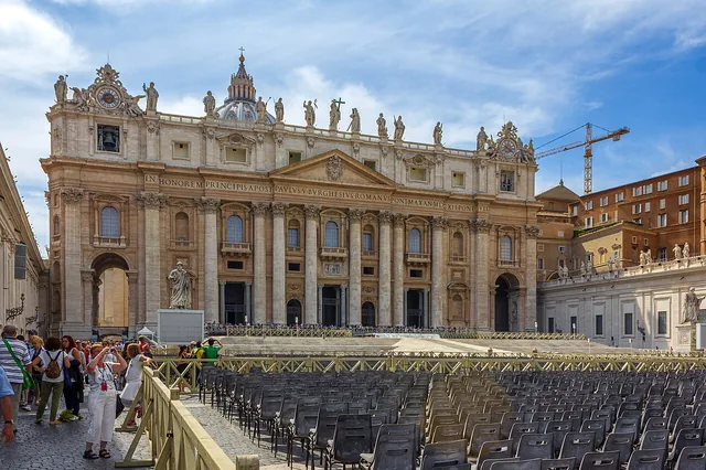 Saint Peter’s Basilica façade viewed from the square, with its historic statues and rows of empty chairs in the foreground.